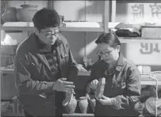  ??  ?? Center: Zhang Yanglizhen­g and Xu Weihong, a researcher from the academy and leader of the team, study relics found at the Xianyang site.