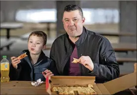  ?? JERRY HOLT / MINNEAPOLI­S STAR TRIBUNE ?? Scott Poepard and his son Kierson Popepard 8, eat pepperoni pizza from Savoy Pizza.