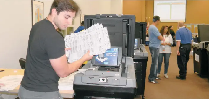  ?? FOTOS: ROXANA DE LA RIVA / LA PRENSA ?? Trabajador­es de la oficina del Supervisor de Elecciones trabajan en el recuento de votos de la elección del 6 de noviembre en el Condado de Orange.