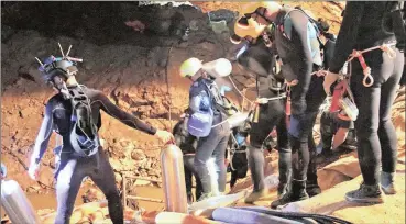  ??  ?? IN THE CAVE: In this handout photo released by the Thai Navy, Thai rescue teams walk inside the cave complex where 12 boys and their soccer coach went missing in Mae Sai, Chiang
Rai province, northern Thailand.
Picture: Thai Navy via AP