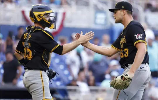  ?? Rhona Wise/Associated Press ?? Pirates pitcher Hunter Stratton and catcher Jason Delay congratula­te each other after the Pirates defeated the Marlins in a baseball game Sunday in Miami. The Pirates are off to a 5-0 start. Last year, they also started hot out of that gate, beginning 20-8.