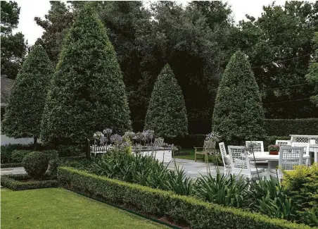  ??  ?? Eagleston hollies pruned into loose conical forms add year-round evergreen structure to the largest of four fountain gardens.