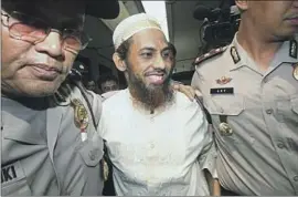  ?? Tatan Syuflana Associated Press ?? UMAR PATEK, center, is escorted by police in Jakarta, Indonesia, in 2011, when he was sentenced for his role in the Bali bombing that killed 202 people.