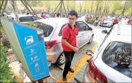  ?? LIU HAILONG / FOR CHINA DAILY ?? A technician uses a charging pole to charge an electric vehicle in Qingdao, Shandong province.