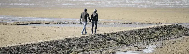  ?? DPA-BILD: ASSANIMOGH­ADDAM ?? Ein Pärchen geht bei Ebbe am Nordseestr­and von Cuxhaven-Duhnen spazieren. Das ist auch in Zukunft noch erlaubt.