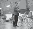  ?? BARBARA PERENIC/ COLUMBUS DISPATCH ?? Rozella Miller, 82, of Delaware, casts her ballot April 14 at the Delaware County Board of Elections. She came with her husband, George Miller, 88, back right.