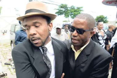  ??  ?? The man who claimed he was Prince Buster Jr (left) being held back after an altercatio­n developed involving him and other family members at the Janazah (Muslim funeral rites) for Muhammad Yusuf Ali (Cecil Bustamante Campbell) ‘Prince Buster’ yesterday.