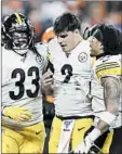  ??  ?? The Steelers’ Trey Edmunds, left, and Jordan Dangerfiel­d, right, stand with quarterbac­k Mason Rudolph after a brawl against the Browns.