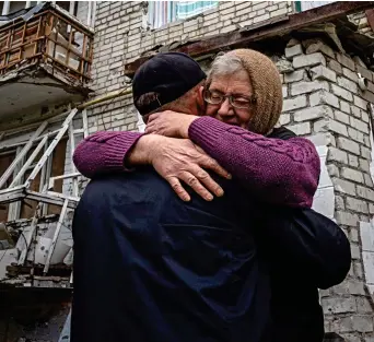  ?? ?? Relief: Izyum resident Yevdokia, 65, hugs her son in front of their shelled house
