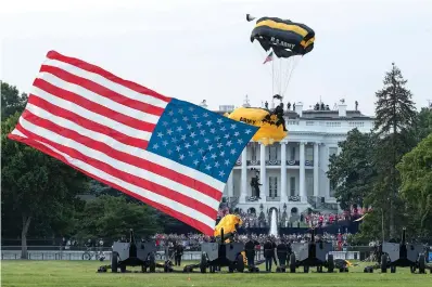  ?? AP Photo/Alex Brandon ?? ■ President Donald Trump and first lady Melania Trump watch as the U.S. Army Golden Knights Parachute Team descends during a “Salute to America” event Saturday on the South Lawn of the White House in Washington.