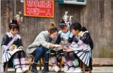  ?? ?? Pan (second from right) and her classmates complete holiday homework with help from their teacher in Dadai Miao village of Congjiang county, Guizhou province, on Feb 25, 2021.