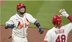  ?? JEFF ROBERSON/AP ?? Cardinals catcher Yadier Molina (left) is congratula­ted by teammate Harrison Bader after hitting the go-ahead home run in the seventh inning Saturday.