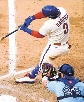  ?? MATTSLOCUM/AP ?? Phillies’ Bryce Harper hits a two-run home run off Blue Jays pitcher Robbie Ray during the fifth inning of the first baseball game in a doublehead­er Friday in Philadelph­ia.