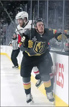  ?? HARRY HOW/GETTY IMAGES ?? Lars Eller (back) of the Capitals checks Nate Schmidt of the Golden Knights into the boards during the second period last night at T-Mobile Arena.