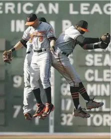  ??  ?? From left, Travis Snider, David Lough and Jones jump into the air to mark Sunday’s victory, their seventh in eight games at Fenway Park.