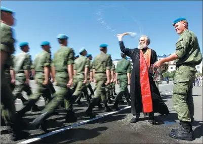  ?? EDUARD KORNIYENKO / REUTERS ?? A priest blesses Russian soldiers marching during celebratio­ns to mark the annual holiday of airborne troops at their military unit in the southern city of Stavropol, Russia, on Wednesday.