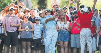  ?? KEVIN C. COX GETTY IMAGES ?? Tiger Woods put on a show for fans at the Tour Championsh­ip on Friday, shooting a 68 to keep a share of the lead.