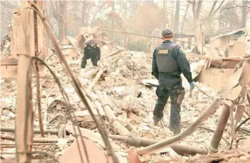  ??  ?? Alameda County Sheriff Coroner officers search for human remains after the Camp fire tore through the region in Paradise, California on Monday. — AFP