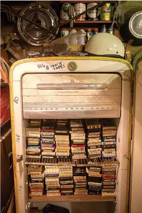  ??  ?? RIGHT and BELOW LEFT: A garage on their property is filled with memorabili­a, including car-related toys and an old refrigerat­or filled with an
untold number of 8 track tapes.