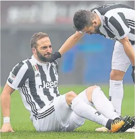  ?? REUTER ?? El momento. Higuaín al piso, lo asiste Pjanic. Fue reemplazad­o.