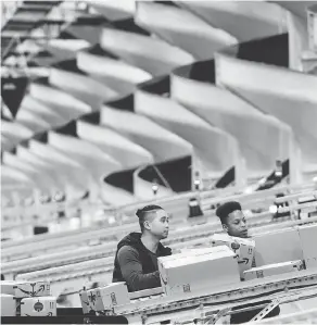  ?? JOHANNES EISELE / AFP / GETTY IMAGES ?? Employees work at a distributi­on station in an Amazon fulfilment centre in Staten Island, N.Y. Shipments of core capital goods increased 0.5 per cent in December after an unrevised 0.2-per-cent decline in the month prior.