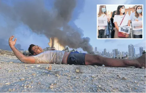  ?? PHOTOS BY AFP ?? A wounded man lies on the ground amid debris as smoke billows in the background at the scene of a massive explosion that hit the port of Beirut in the heart of the Lebanese capital. Rescuers searched for survivors in Beirut after a cataclysmi­c explosion at the port sowed devastatio­n across entire neighbourh­oods.
INSET Women wearing face masks hold signs reading ‘History repeats itself as well as the tragedy, Toulouse 2001, Beyrouth 2020’ in Toulouse.