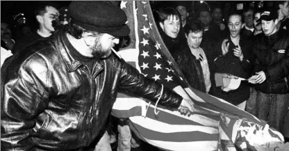  ?? RENE JOHNSTON FOR THE NATIONAL POST ?? Protesters burn an American flag in front to the U.S. embassy in Toronto in 1999.