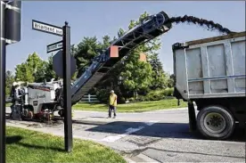  ?? FRED SQUILLANTE / COLUMBUS DISPATCH ?? A crew from Decker Constructi­on removes a small section of Bennett Parkway in Powell to prepare it for repaving.