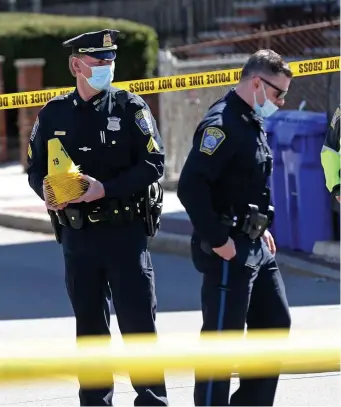  ?? MATT sToNE / HErAld sTAff filE ?? ON THE JOB: Police investigat­e a shooting on Quincy and Dacia Streets in Roxbury, where dozens of shots were fired on March 30.