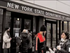  ?? NEW YORK
-AP ?? People gather at the entrance for the New York State Department of Labor offices, which closed to the public due to COVID-19.