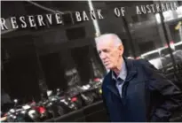  ??  ?? SYDNEY: A man walks past the Reserve Bank of Australia sign in Sydney yesterday. Australia’s central bank held interest rates at a record low 1.50 percent yesterday ahead of quarterly economic growth data analysts expect to come in weak. — AFP