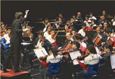  ??  ?? The Orchestra of the Filipino Youth (OFY) with artistic director and co-founder Jovianney Emmanuel Cruz (top). Olivier Ochanine conducts the OFY kids with the musicians of the Philippine Philharmon­ic Orchestra (above).