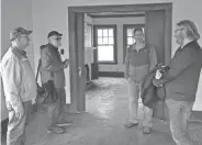  ?? LEONARD HAYHURST/TRIBUNE ?? Tom Barcroft and Lanny Spaulding of Our Town Coshocton, foreground, talk with architect Rick Hawksley and Jeremy Bradshaw of Bradkins LLC while standing in a unit part of the Row Houses on Chestnut Street. It’s hoped a $50,000 Paul Bruhn Historic Preservati­on Grant will be received to help with restoratio­n efforts.