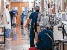  ?? Mark Mulligan / Staff photograph­er ?? Machines are worked on Tuesday inside an ICU that has been converting rooms to serve COVID patients in theMedical Center.