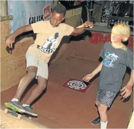  ??  ?? PASSING ON THE STOKE: Kye Macgregor, right, mentoring Liyema Nxobo on a half-pipe skate ramp