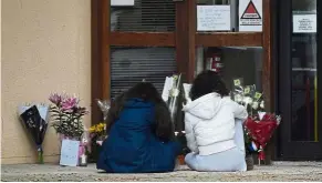  ??  ?? Loss and grief: Students sitting in front of a memorial at the school in Conflans Saint-Honorine, after the teacher was decapitate­d. — AFP