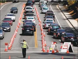  ?? Gary Coronado Los Angeles Times ?? VEHICLES inch along at the Dodger Stadium coronaviru­s testing site in June. The site was closed over the weekend after neighbors complained of traff ic.