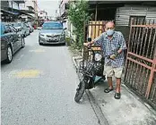 ??  ?? 千百家新村居民黄坤元­担忧一旦道路重铺，柏油层会增高，导致居民的摩托车出入­不便。