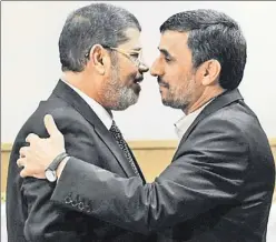  ??  ?? Not such a warm embrace: Egypt’s Mohammed Mursi (l.) with Iran’s Ahmadineja­d in Tehran yesterday.
