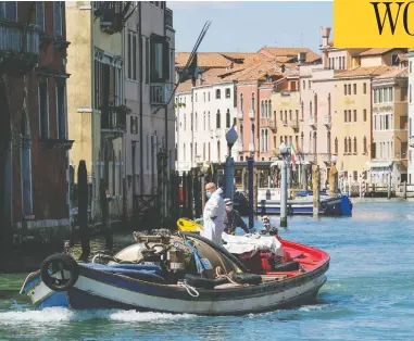  ?? MANUEL SILVESTRI / REUTERS ?? Workers resume their activities in Venice, Italy, on Monday, as the country begins to slightly relax restrictio­ns.