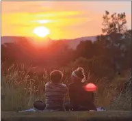  ?? H John Voorhees III / Hearst Connecticu­t Media file photo ?? Friends Ricky Westby, of Danbury, left, and Aly Peet, of New Fairfield, watch the sunset by Lee Farms Corporate Park in Danbury on June 16, 2016. Switching to permanent daylight saving time would mean later sunsets in the winter, but later sunrises too.