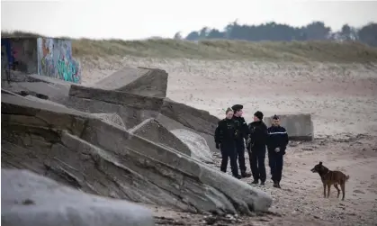  ?? Photograph: Lou Benoist/AFP/Getty Images ?? Gendarmes of the canine ‘cynophile’ unit patrol the Blankenese battery on Néville beach.