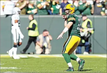  ??  ?? Aaron Rodgers of the Green Bay Packers celebrates throwing a touchdown pass against the Oakland Raiders at Lambeau Field on Sunday in Green Bay, Wisconsin.