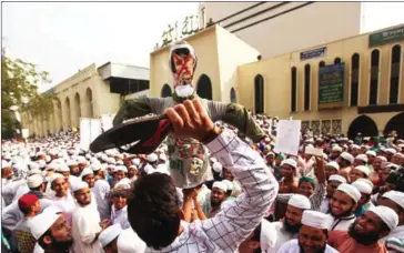  ?? RAJIB DHAR/AFP ?? Bangladesh­i activists of several Islamic groups hit an effigy of Myanmar’s de facto leader Aung San Suu Kyi during a protest rally against the persecutio­n of Rohingya Muslims in Myanmar last week.