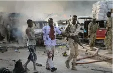  ??  ?? A Somali soldier helps a civilian who was wounded in a blast in the capital of Mogadishu, Somalia, last Saturday