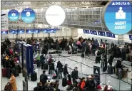  ?? ABBIE PARR — THE ASSOCIATED PRESS ?? Travelers check in for their flights at kiosks in Terminal 1 at Minneapoli­s St. Paul Airport on Wednesday. Forecaster­s are warning of treacherou­s holiday travel and lifethreat­ening cold for big parts of the nation.