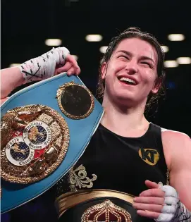  ?? STEPHEN McCARTHY/SPORTSFILE ?? Katie Taylor with the spoils of war after beating Victoria Bustos in their unificatio­n fight in New York