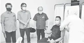  ??  ?? TINJAU: Uggah menyertai Razaili (kanan) bersama Razi melihat salah seorang petugas barisan hadapan diberikan suntikan vaksin di Dewan Panglima Rentap, Betong semalam.