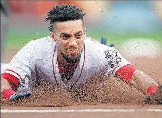  ?? THE ASSOCIATED PRESS] [GARY LANDERS/ ?? The Reds’ Billy Hamilton slides into third base with a triple in the first inning.