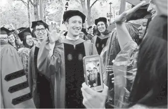  ?? STEVEN SENNE, AP ?? Facebook CEO and Harvard dropout Mark Zuckerberg, center, greets Harvard grads Thursday.